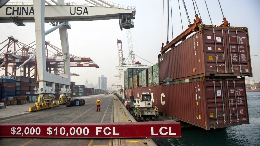 A container ship with stacked containers sailing on the ocean, representing international trade