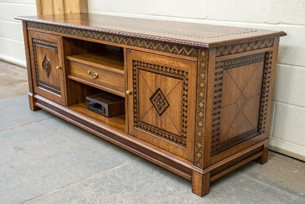 A craftsman working on a unique, ornately designed piece of furniture in a workshop